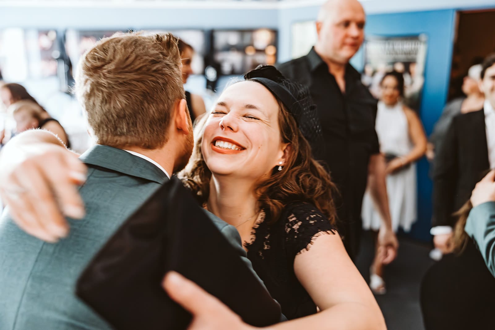Theater Narrenschiff Unna Lindenbrauerei Kühlschiff Unna Hochzeitsfotograf - Hochzeitsgast weiblich freut sich für das Hochzeitspaar und umarmt den Bräutigam