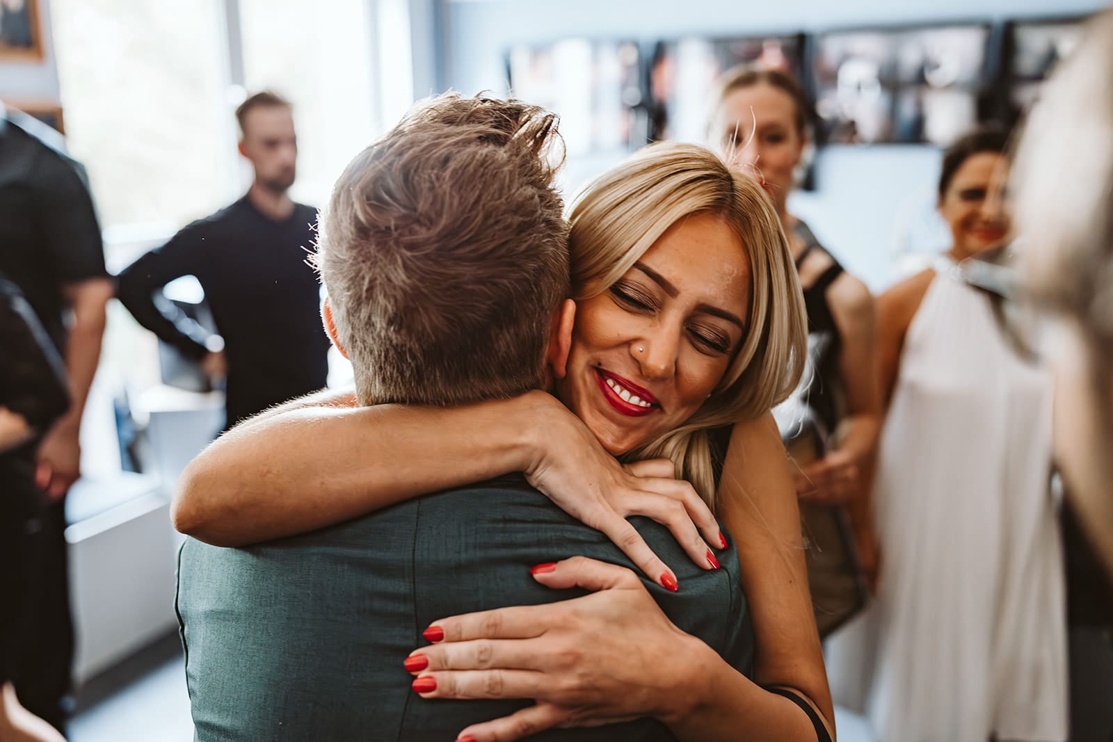 Theater Narrenschiff Unna Lindenbrauerei Kühlschiff Unna Hochzeitsfotograf - junge blonde Frau mit roten Fingernägeln umarmt Bräutigam Gratulation