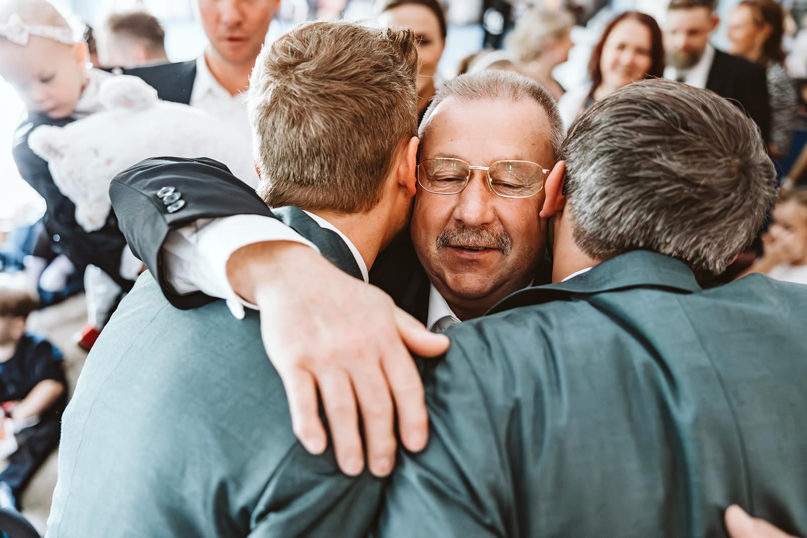 Theater Narrenschiff Unna Lindenbrauerei Kühlschiff Unna Hochzeitsfotograf - Opa umarmt schwules homosexuelles gleichgeschlechtliches Hochzeitspaar und schließt dabei die Augen
