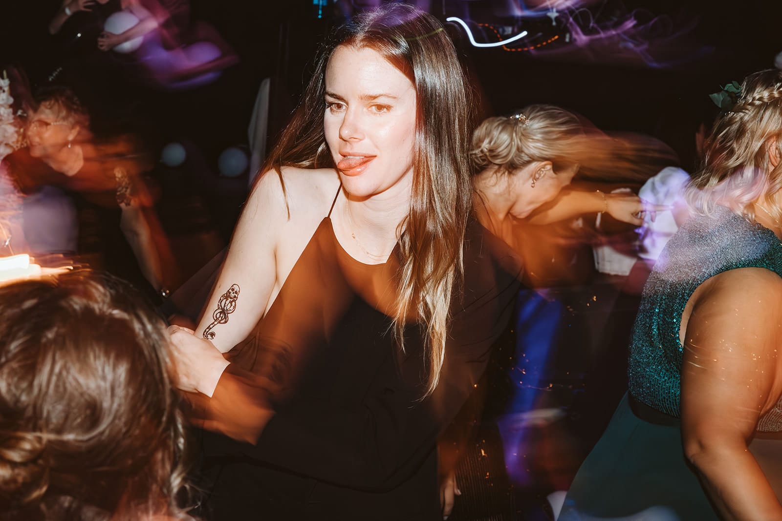 Theater Narrenschiff Unna Lindenbrauerei Kühlschiff Unna Hochzeitsfotograf - Junge Frau streckt die Zunge raus und zeigt ihr Tatoo auf Hochzeitsparty