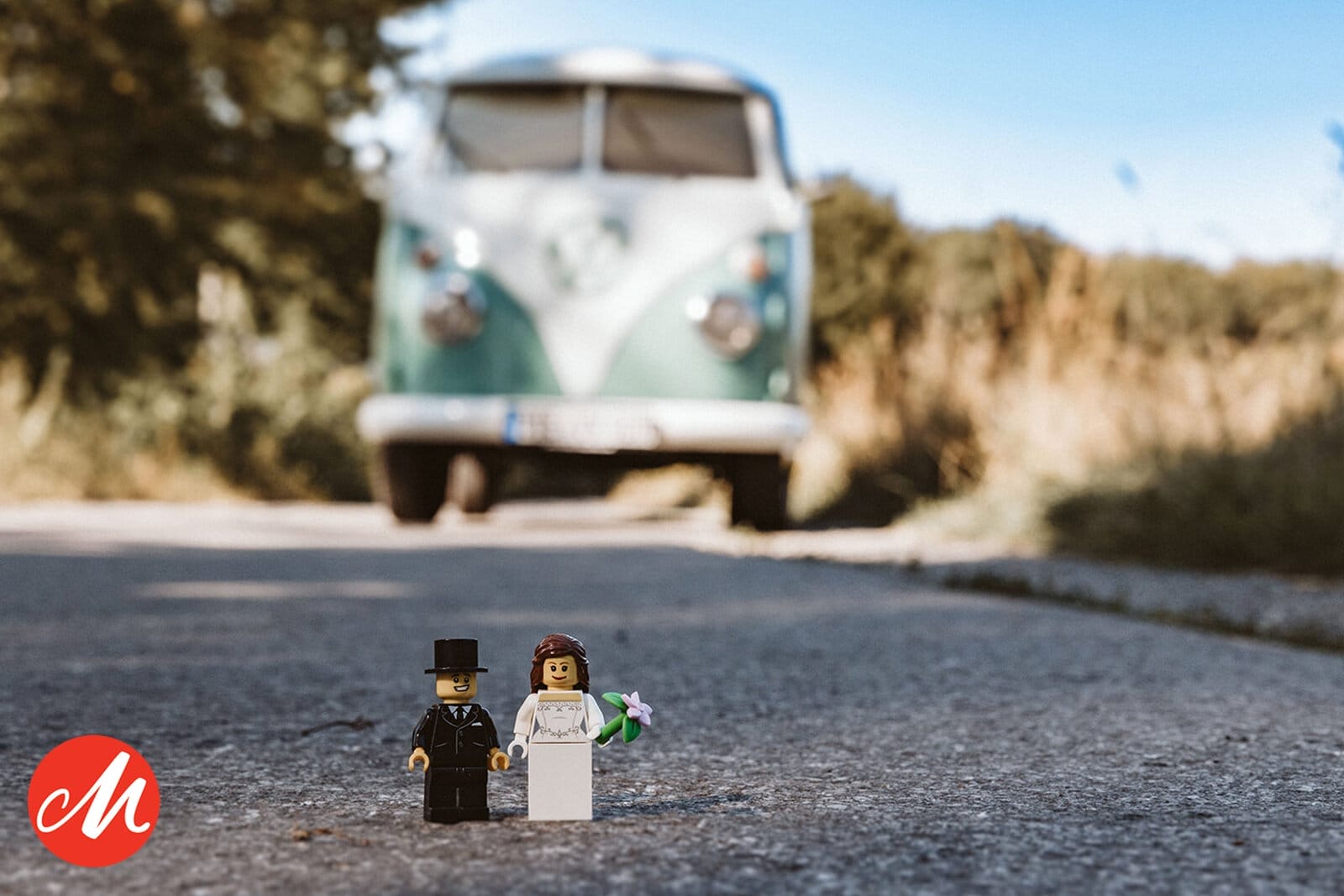 Hochzeit Heiraten Hochzeitsfotograf Dominik Neugebauer - Lego Männchen in Form eines Brautpaars vor einem VW Bulli. Die Lego Männchen stehen auf der Straße.