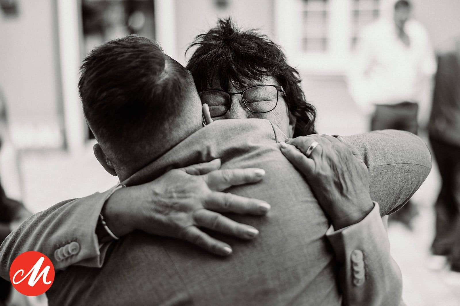 Hochzeit Heiraten Hochzeitsfotograf Dominik Neugebauer - Bräutigam umarmt die Brautmutter, die überglücklich den Bräutigam umarmt und drückt.