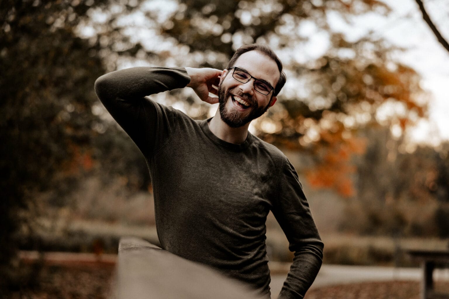 Hochzeit Heiraten Hochzeitsfotograf Dominik Neugebauer - Dominik kratzt sich mit seiner rechten Hand am Hinterkopf und lächelt freundlich in die Kamera.