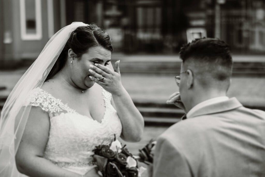 Hochzeit Heiraten Hochzeitsfotograf Dominik Neugebauer - Braut ist beim First Look zu tränen gerührt und wischt sich durchs Gesicht, um die Tränen abzutrocknen.