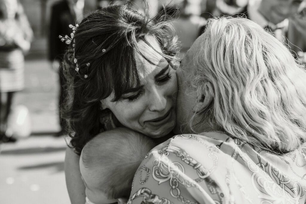 Hochzeit Heiraten Hochzeitsfotograf Dominik Neugebauer - Gratulation der Brautmutter für die frisch vermählte Braut. Die Braut hält dabei ihren Sohn in den Armen. Die Braut ist den Tränen nahe.