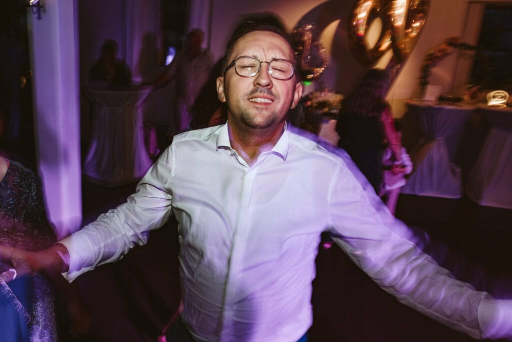 Hochzeit Heiraten Hochzeitsfotograf Dominik Neugebauer - Hochzeitsgast lässt auf der Hochzeitsparty all seine Emotionen freien lauf und tanzt.