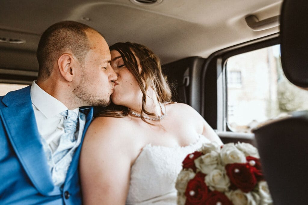 St. Marien Kirche Schloss Diersfordt Hochzeitsfotograf - Hochzeitspaar küsst sich im Jeep