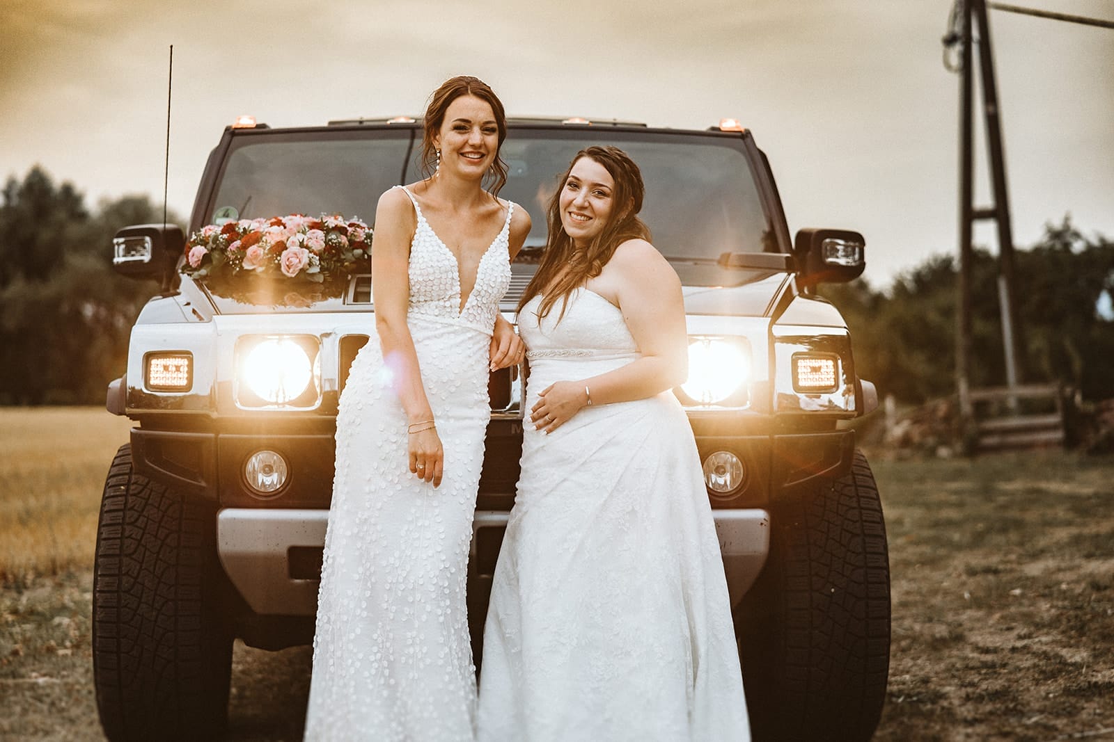 St. Marien Kirche Schloss Diersfordt Hochzeitsfotograf - Braut und Braut von einer anderen Hochzeit posieren vor einem Jeep