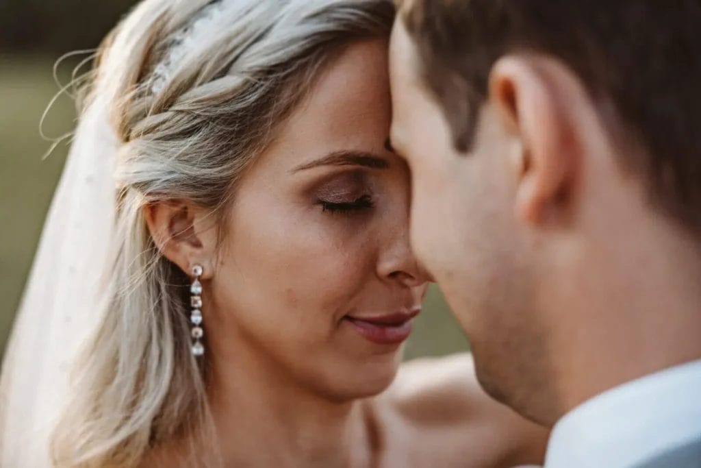 Auf der Hochzeit perfekt aussehen - Braut und Bräutigam schließen die Augen. Stirn an Stirn