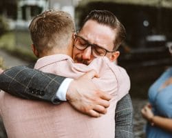 Brautjungfern und Brautführer - Trauzeuge umarmt Bräutigam und fängt das Weinen an