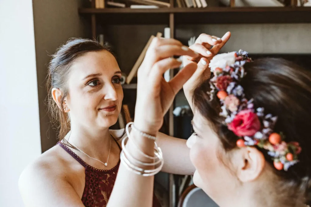 Der perfekte Tagesablauf einer Hochzeit - Trauzeugin justiert Blumenkranz auf Kopf der Braut