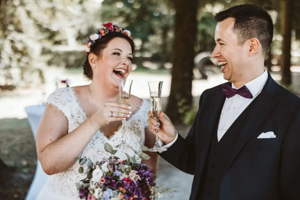 Der perfekte Tagesablauf einer Hochzeit - Braut und Bräutigam stoßen auf Hochzeit mit Sektglas an