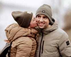 Engagement Session - Paar küsst sich mit Mützen zur herbstlichen Jahreszeit