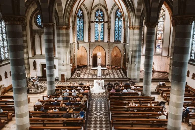 Freie Trauung, kirchliche Trauung und Standesamt - Heiraten mit Vorteilen und Nachteilen - Weitwinkel-Aufnahme von Hochzeit in einer katholischen Kirche