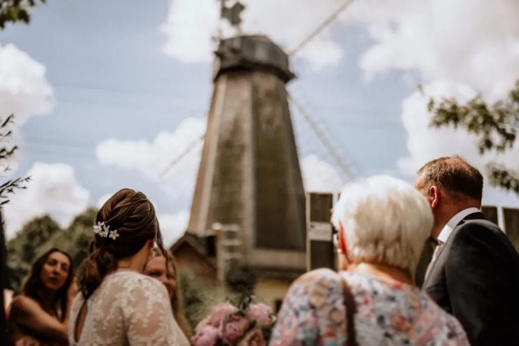 Freie Trauung, kirchliche Trauung und Standesamt - Heiraten mit Vorteilen und Nachteilen - eine Mühle im Hintergrund Brautpaar