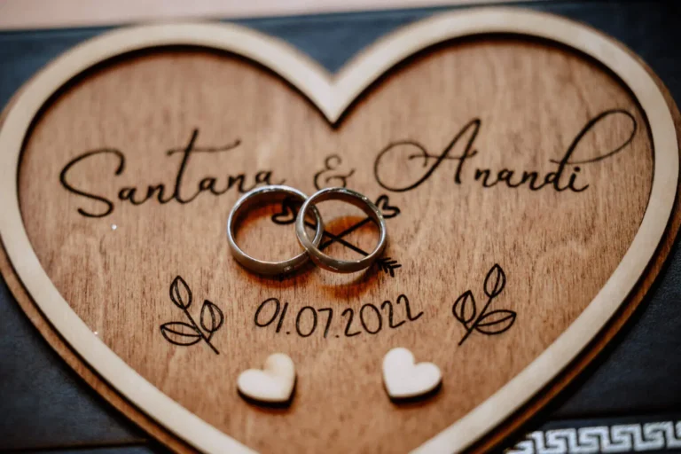 Namensänderungen nach der Hochzeit - Checkliste, Fristen und Gedanken - Zwei Eheringe auf einem Herz aus Holz abgelegt