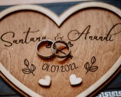Namensänderungen nach der Hochzeit - Checkliste, Fristen und Gedanken - Zwei Eheringe auf einem Herz aus Holz abgelegt