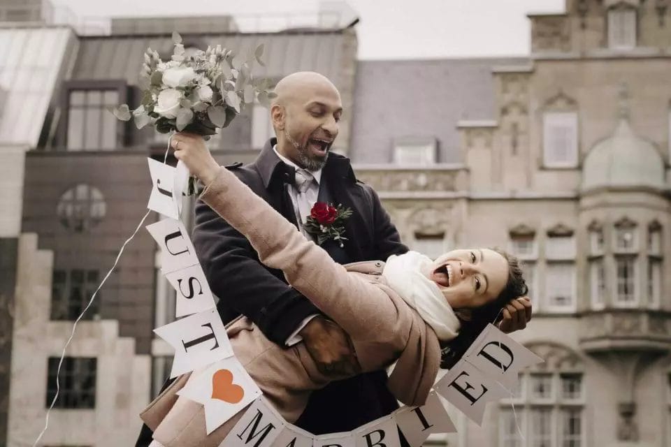 Regen am Hochzeitstag - Paar macht eine Fallfigur vor dem Standesamt Düsseldorf