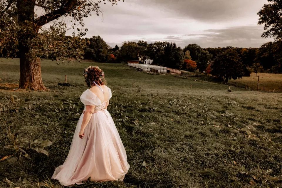 Unplugged Wedding - Handy und Smartphones zu Hause lassen - Braut schaut in die Weite des Felds