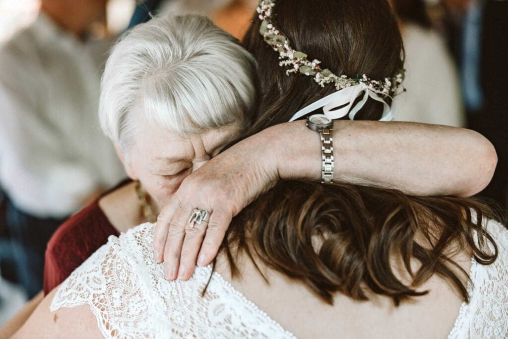 Hochzeitsfotograf Remscheid Hochzeit Heiraten Hochzeitsfotos - Die Brautmutter umarmt die Braut. Sie ist den Tränen sehr nahe. Die Brautmutter trägt Schmuck am Finger und eine Uhr am Handgelenk