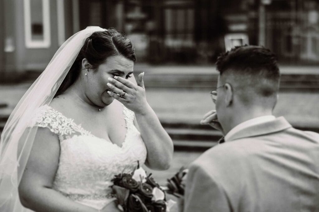 Hochzeitsfotograf Mülheim an der Ruhr Hochzeit Heiraten Hochzeitsfotos - Braut ist beim First Look zu tränen gerührt und wischt sich durchs Gesicht, um die Tränen abzutrocknen