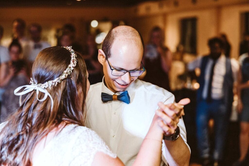 Hochzeitsfotograf Mülheim an der Ruhr Hochzeit Heiraten Hochzeitsfotos - Der Bräutigam tanzt mit der Braut den gemeinsamen Hochzeitstanz. Er lächelt nach unten und freut sich über den Hochzeitstanz ersichtlich