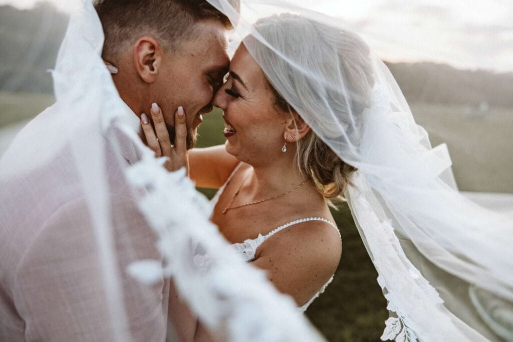 Hochzeitsfotograf Oberhausen Hochzeit Heiraten Hochzeitsfotos - Die Braut hält mit ihrer linken Hand die Wange des Bräutigams. Ihre beiden Nasen berühren sich. Der Schleier der Braut ist zu sehen, unter dem der Bräutigam verhüllt ist