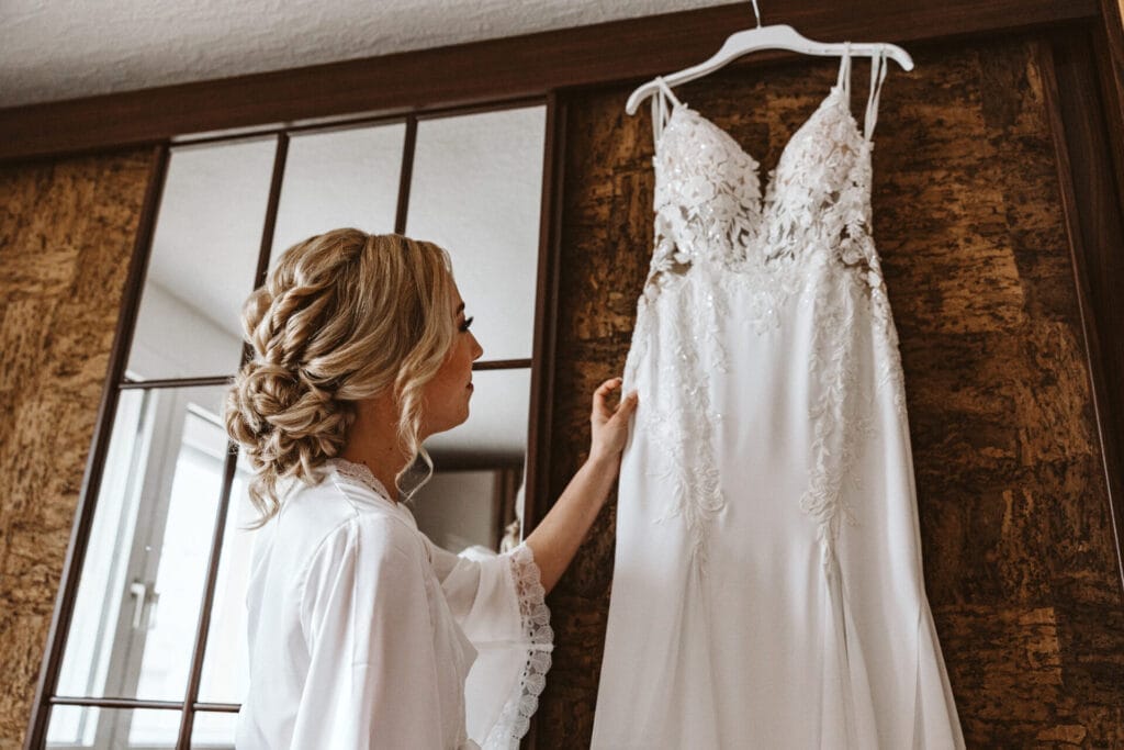 Pro und Contra für das Mieten eines Hochzeitskleides - Braut sieht sich ihr neues Hochzeitskleid an, bevor sie es sich anzieht