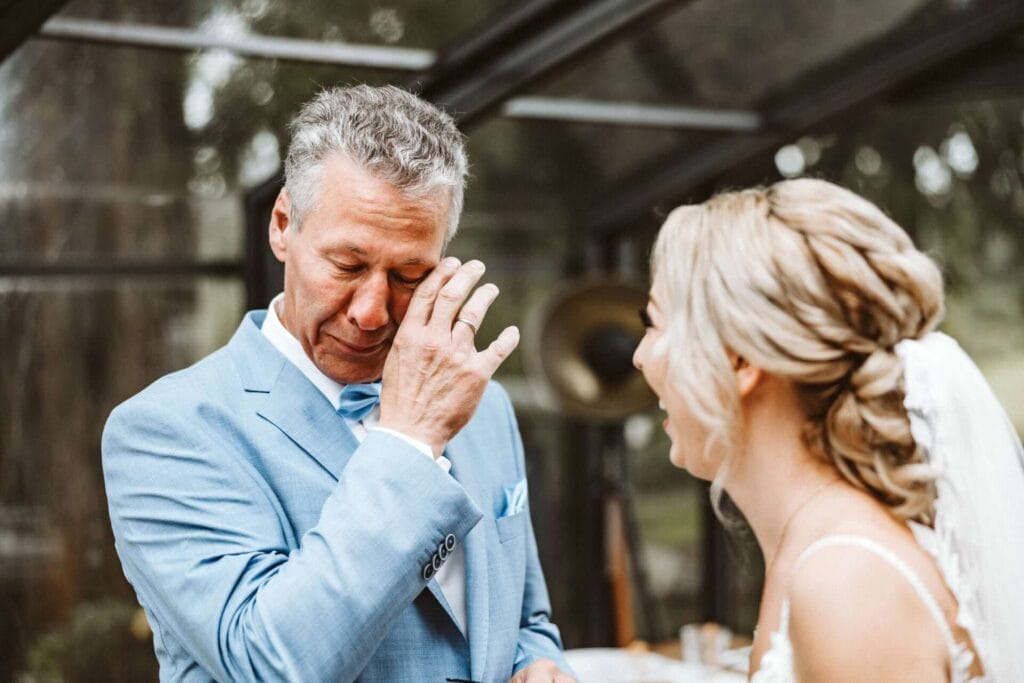 Hochzeitsfotograf Dortmund Hochzeit Heiraten Hochzeitsfotos - Brautvater ist beim First Look der Braut so sehr gerührt, dass er zum Weinen anfängt. Tränen kullern ihn über das Gesicht. Die Braut lächelt sichtlich gerührt zu ihrem Vater, zum Brautvater