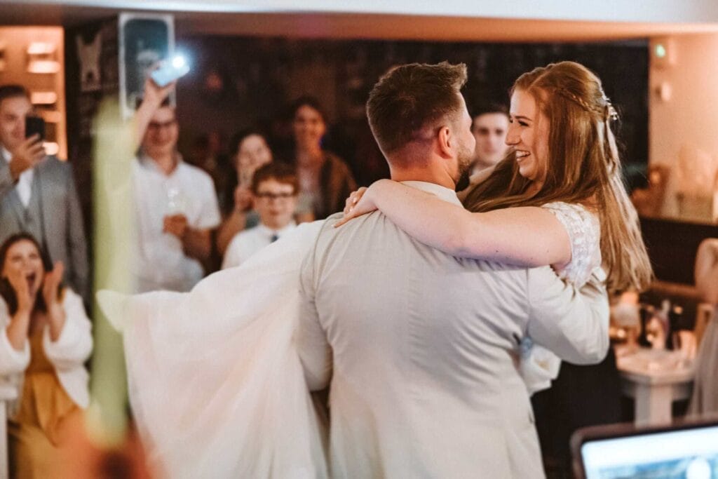 Hochzeitsfotograf Dortmund Hochzeit Heiraten Hochzeitsfotos - Bräutigam hebt seine Braut auf dem Hochzeitstanz nach oben. Er trägt die Braut auf seinen Armen. Beide lächeln sich an