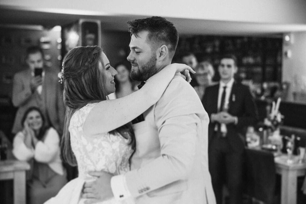 Hochzeitsfotograf Marl Hochzeit Heiraten Hochzeitsfotos - Braut und Bräutigam beginnen ihren Hochzeitstanz. Im Hintergrund sind Gäste zu sehen, die diesen Tanz mit dem Smartphone iPhone Android Handy aufnehmen