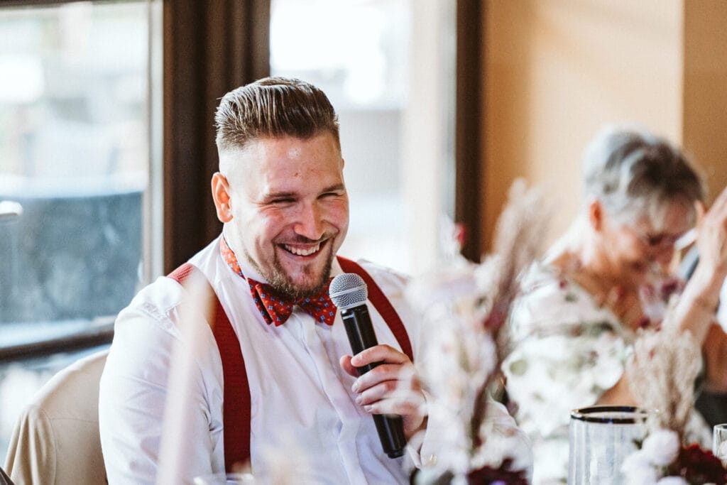 Was Euch niemand über Euren großen Tag verrät - Bräutigam hält Mikrofon in der Hand für Ansprache