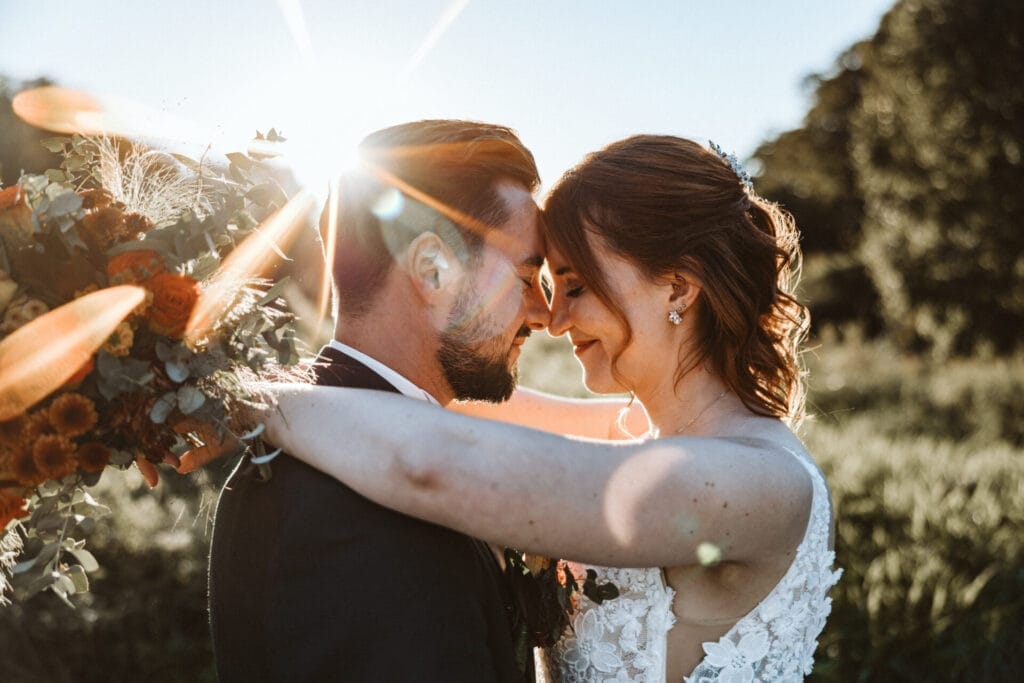 Was Euch niemand über Euren großen Tag verrät - Brautpaar während Sonnenuntergangsstimmung mit Sundown Strahlen der Sonne
