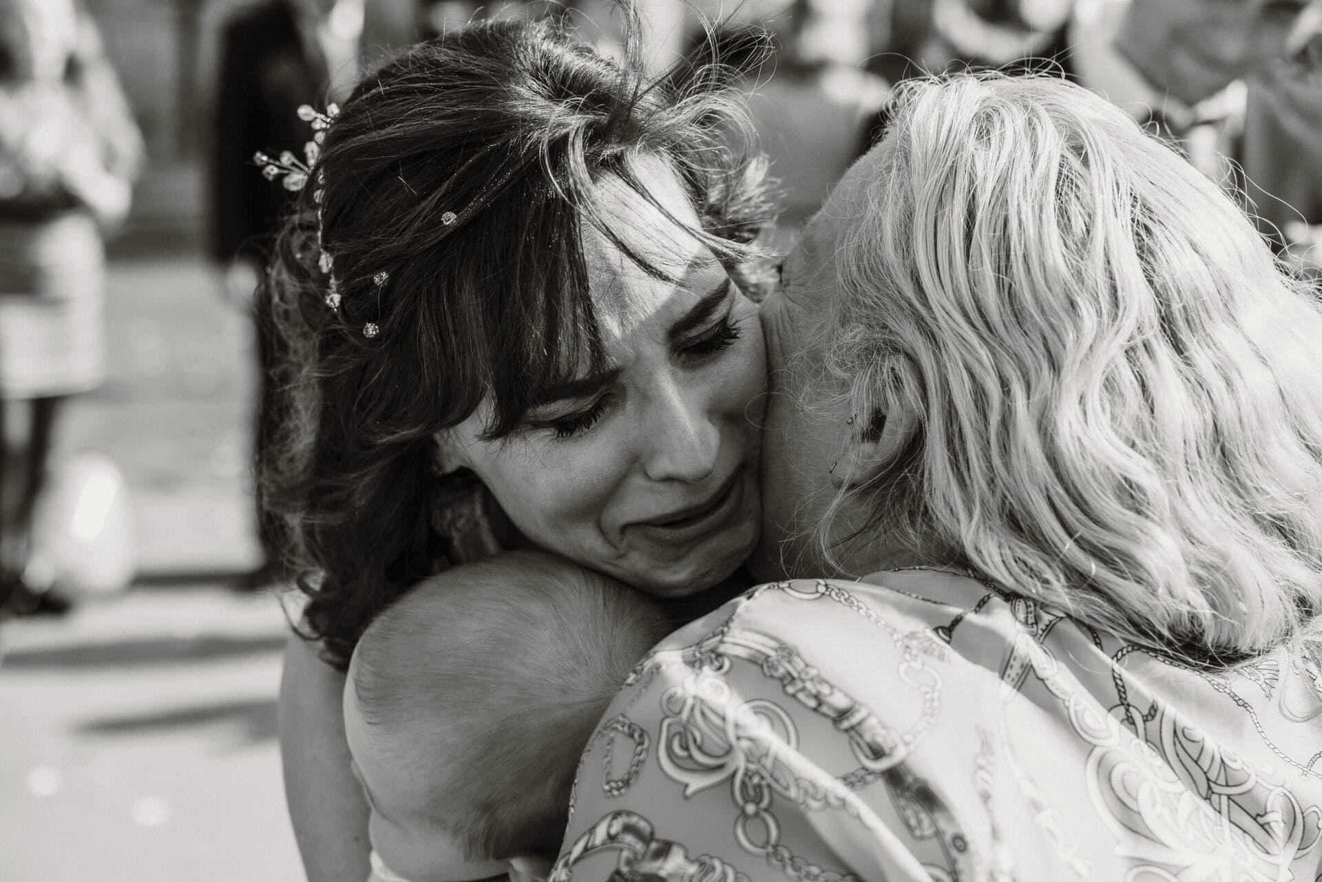 Hochzeitsfotograf Bergkamen Hochzeit Heiraten Hochzeitsfotos - Gratulation der Brautmutter für die frisch vermählte Braut. Die Braut hält dabei ihren Sohn in den Armen. Die Braut ist den Tränen nahe