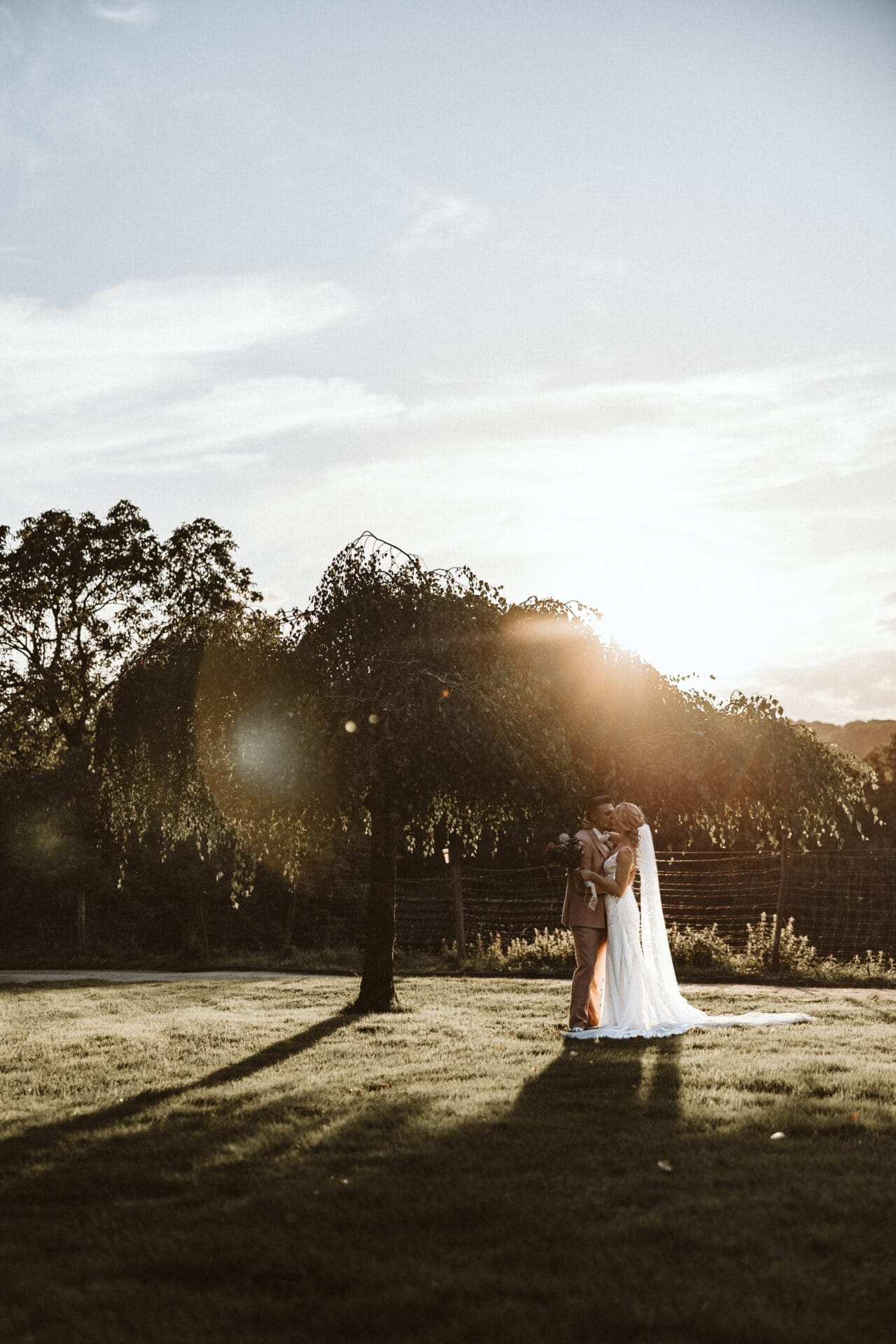 Hochzeitsfotograf Herten Hochzeit Heiraten Hochzeitsfotos - Brautpaar küsst sich unter einem Baum bei Sonnenuntergang