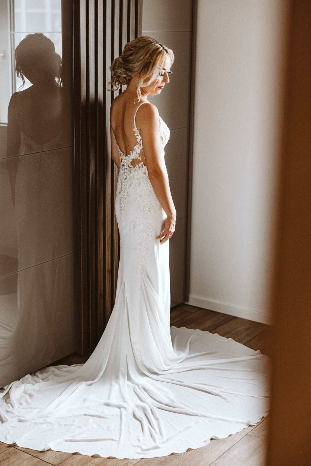 Hochzeitsfotograf Krefeld Hochzeit Heiraten Hochzeitsfotos - Braut steht vor Kleiderschrank. Brautkleid ist aufgefaltet