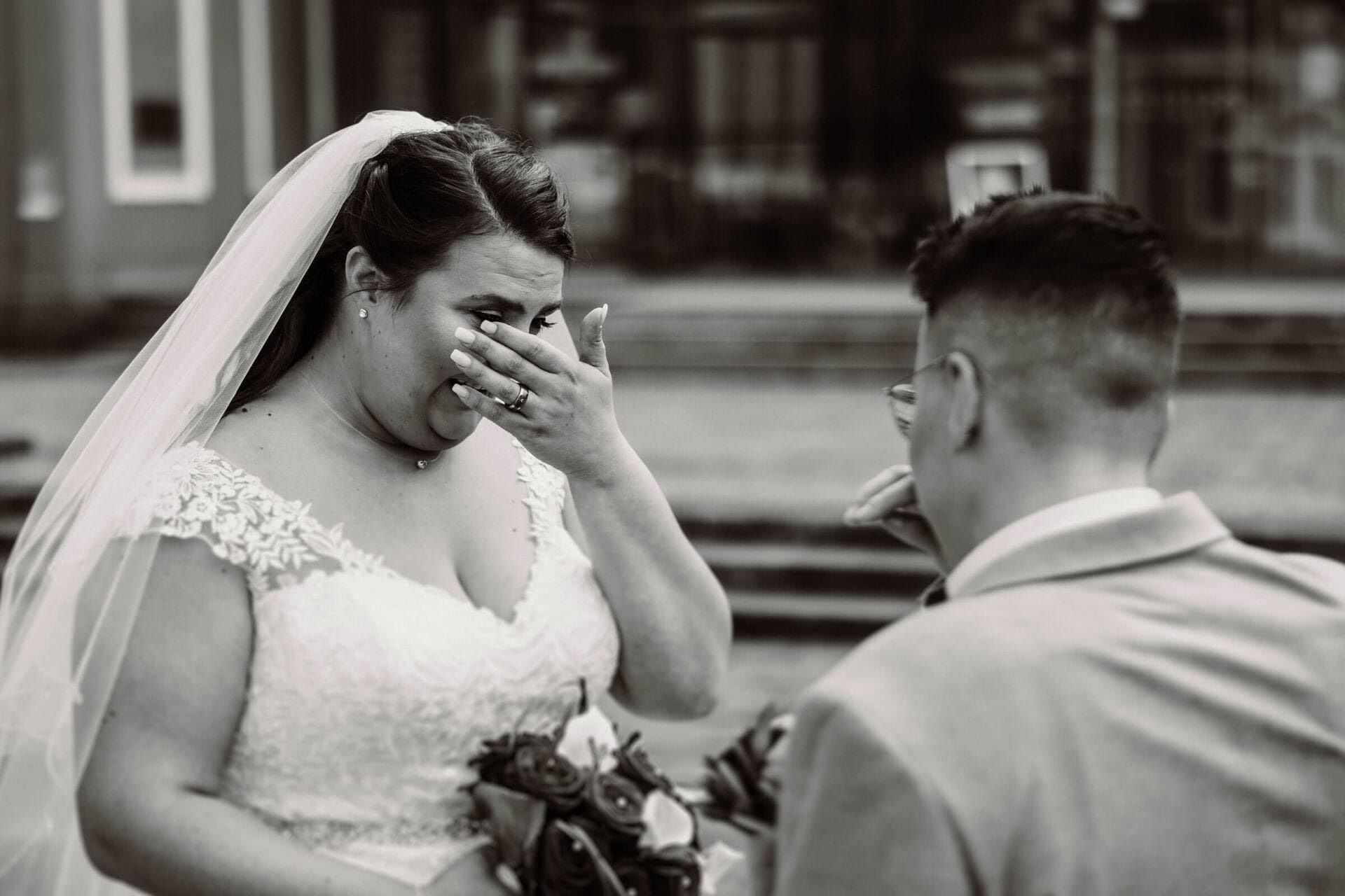 Hochzeitsfotograf Krefeld Hochzeit Heiraten Hochzeitsfotos - Braut ist beim First Look zu tränen gerührt und wischt sich durchs Gesicht, um die Tränen abzutrocknen