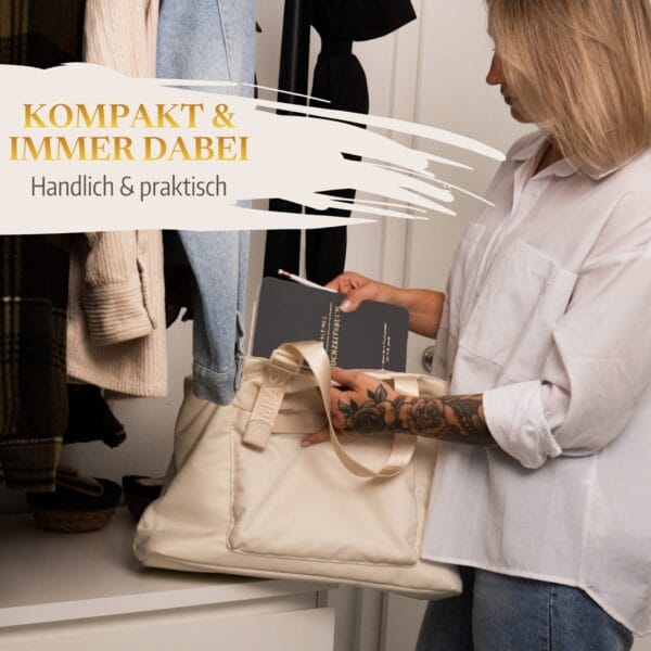 Mein kleines Hochzeitsbuch Hochzeitsplaner Wedding Planner Grau 7 Mein kleines Hochzeitsbuch Hochzeitsplaner Wedding Planner Grau - Kompakt und immer dabei - handlich und praktisch - Zukünftige Braut packt Hochzeitsplaner Wedding Planner in die Handtasche vor einer Garderobe